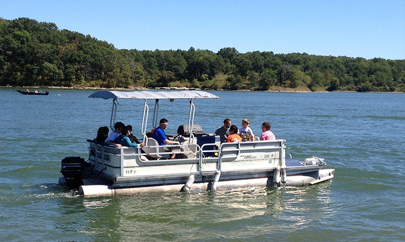 A group of fishermen in a pontoon boat on the lake