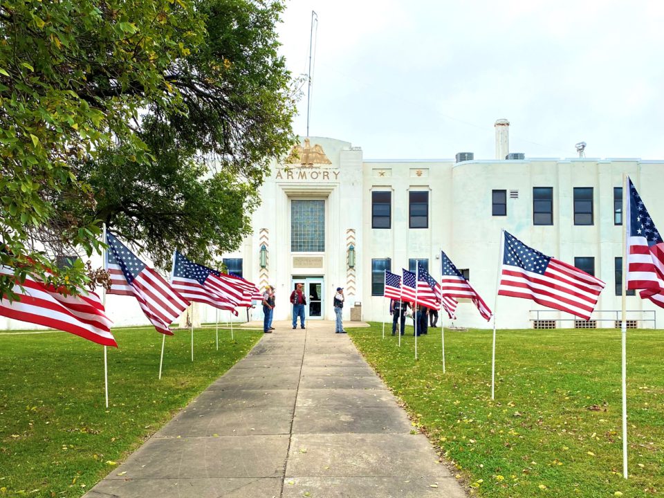 A photograph of the walkway, lined with American flags, leading to the entrance of the National Guard Hall of Fame