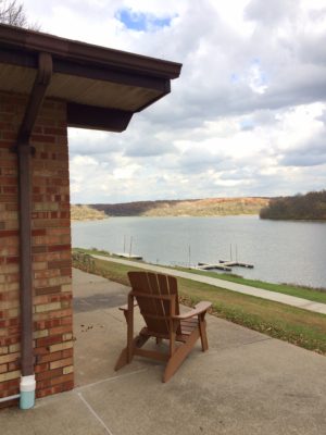 A photograph of a patio chair overlooking a lake in Kirksville
